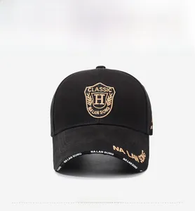 Detail of gold classic crest embroidery and lettering on a black cotton baseball cap