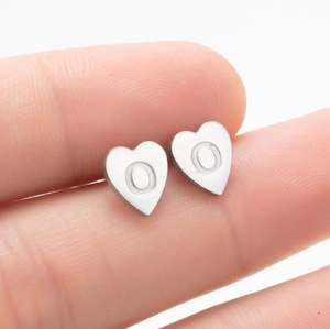Détail macro d'une boucle d'oreille cœur en acier inoxydable avec gravure lettre O