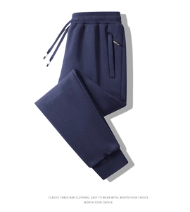 Detail of dark blue jogger pants featuring drawstring waist and secure zipper pocket
