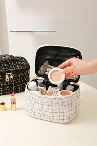 Macro detail of large capacity tweed makeup bag with interior mesh pockets and gold zipper