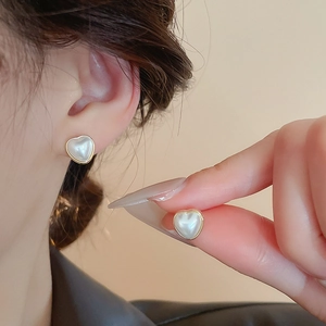Vue détaillée de boucles d'oreilles cœur en perles avec bordure dorée et style français