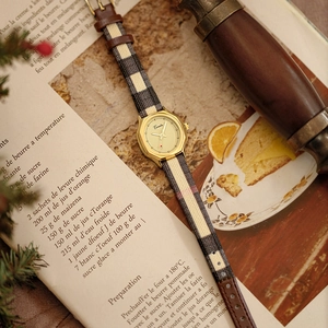 Vintage luxury ladies oval watch with gold case and beige plaid leather strap