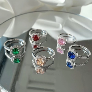 Macro shot of halo silver rings with emerald, ruby, sapphire and pink zircon stones