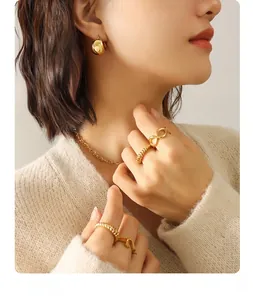 Model wearing a set of 18K gold-plated stainless steel jewelry with rings and earrings