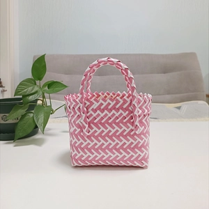 Close-up of pink and white woven tote bag texture with durable plastic handle