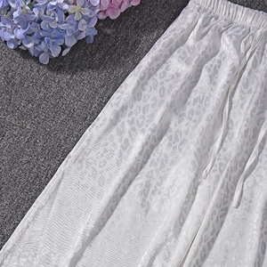 Detail of white leopard jacquard satin trousers with elastic drawstring waistband