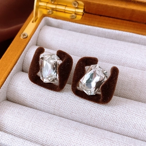 Detail of square earrings with dark brown flocking and clear emerald-cut crystal stones