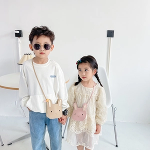 Close-up of adorable cartoon rabbit crossbody bags for kids in beige and pink PU leather