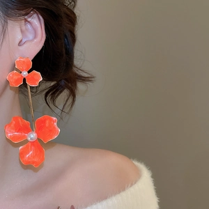 Detailed side view of elegant orange flower drop earrings with white pearls and gold links