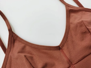 Macro view of brick red ribbed cotton sports bra showing neckline stitching quality