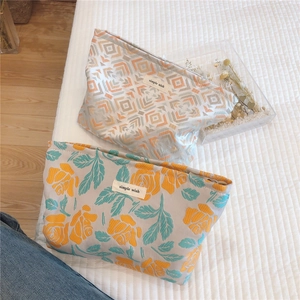Macro shot of two textile cosmetic bags with floral and geometric woven patterns
