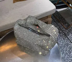Detail of silver rhinestone knotted handbag showing shimmering crystals and top zipper closure