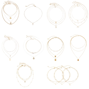 Golden multi-layer necklace set with pearls and geometric pendants on white background