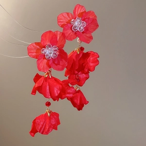 Detailed view of red crystal flower tassel earrings with lightweight fabric petals and gold beads