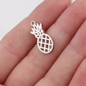 Detailed close-up of a hollow pineapple stainless steel pendant held in hand for scale