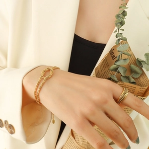 Chic gold-plated knot bracelet and chain ring set for women in elegant lifestyle setting