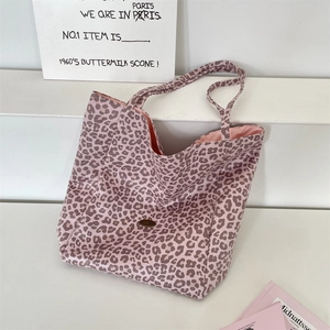 Close-up of pink leopard print canvas tote bag with reinforced handles and metal logo