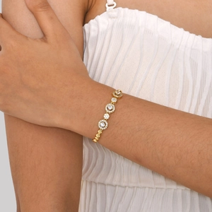 Detailansicht des Goldarmbands mit Zirkonia-Anhängern am Handgelenk des Models