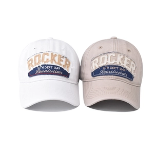 Detail of vintage washed cotton baseball caps with rocker embroidery and frayed edge patches