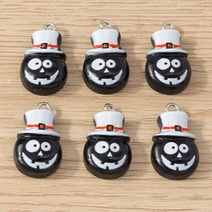 Detail of cartoon ghost charms with white top hats on light wood background for DIY jewelry