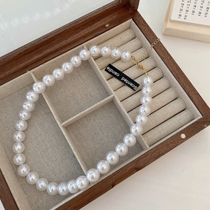 French vintage pearl necklace with golden metal clasp in a wooden jewelry box