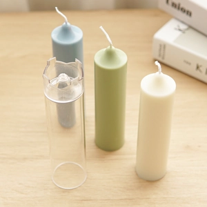 Church spire cylinder candle mold with finished blue, green, and cream wax candles