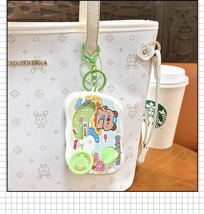 Creative Capybara car game machine keychain hanging on a white textured handbag.