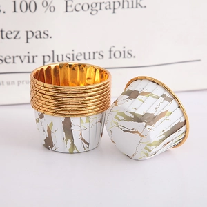 Macro detail of white and gold marble patterned paper baking cups with rolled edges