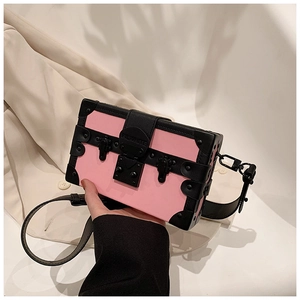 Detail of pink box bag with black rivet corners and metal push-lock buckle
