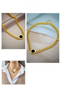 Detail of gold chunky Cuban chain necklace with a black round Roman numeral pendant