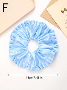 Détail d'un chouchou en satin bleu clair de 18 cm de diamètre avec une texture plissée