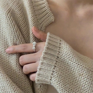 Close-up of 925 sterling silver bow ring with twisted rope texture on a model hand