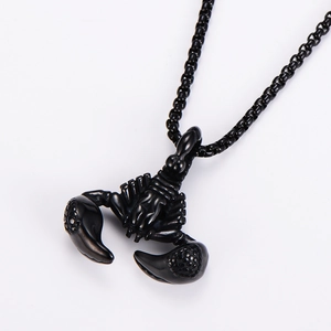 Close-up of black metal scorpion pendant with detailed bead chain on white background