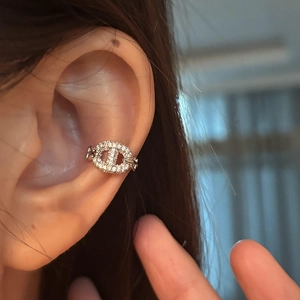 Macro detail of silver pig nose ear cuff with white cubic zirconia pavé setting