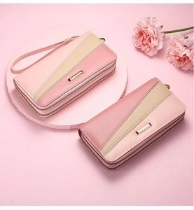 Macro shot of dual-zipper pink and beige leather wallet with chic gold trim