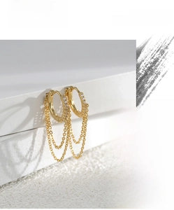 Macro detail of 18K gold fringe hoop earrings with pavé cubic zirconia accents