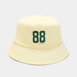 Detail of beige cotton bucket hat featuring green 88 print and wide brim for sun protection