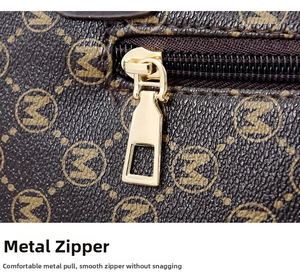 Detail of light gold alloy zipper puller and monogrammed leather on luxury shoulder bag