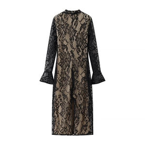 Detail of elegant black lace dress with floral mesh overlay and flared ruffle sleeves