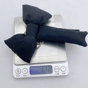 Weight measurement of 17.2g for a black fabric bow charm on a digital scale