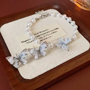 Parure papillon élégante avec bracelet en perles et boucles d'oreilles zircon sur plateau