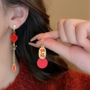 Close-up of red and gold Chinese New Year tassel earrings with Na Fu character details