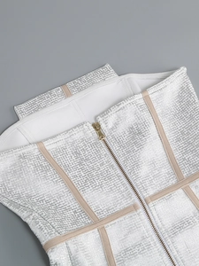 Détail de la robe bandage argentée avec bretelles beiges et fermeture éclair en métal doré