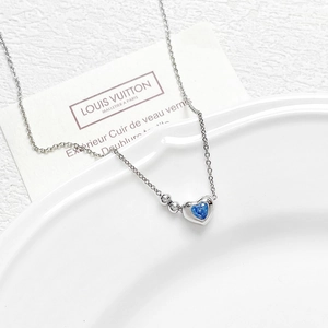 18k gold plated heart pendant necklace with blue cubic zirconia on a white ceramic tray