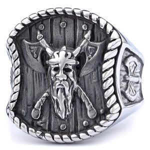 Macro shot of Viking warrior relief and crossed axes on two-tone stainless steel ring