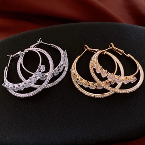 Detail showing gold and silver double hoop earrings with cubic zirconia inlay on velvet