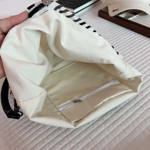 Detail of internal linen lining with a zipper pocket in black and white striped tote bag