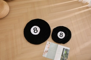 Detail view of two black billiard No. 8 plush rugs on herringbone wood flooring