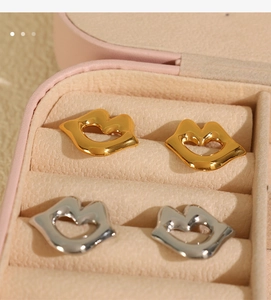 Macro detail of lip-shaped 18k gold and silver plated stainless steel stud earrings
