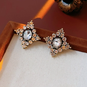 Macro dettagliata di orecchini a stella dorati con strass brillanti e design vintage